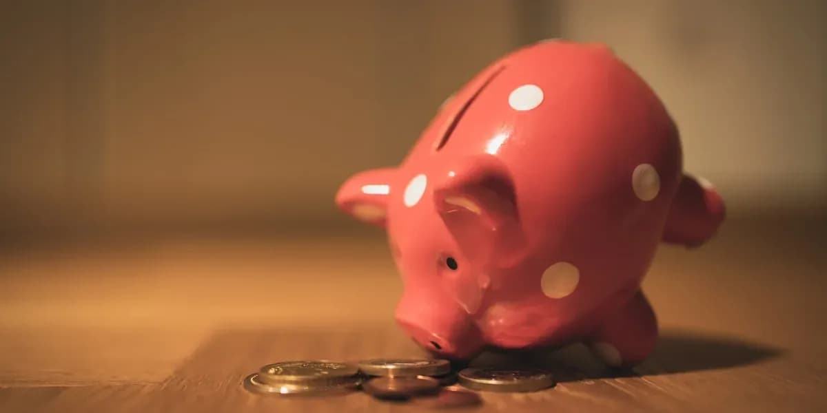 Piggy bank with coins on clean white background